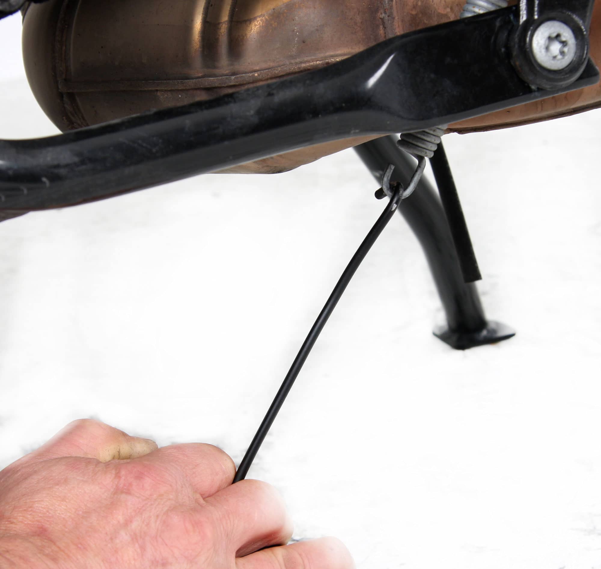 Outil pour accrocher le ressort de traction sur les béquilles principales